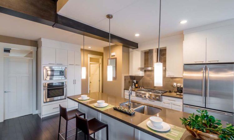 Contemporary kitchen showcasing a modern design with a central island, white cabinetry, and state-of-the-art stainless steel appliances.